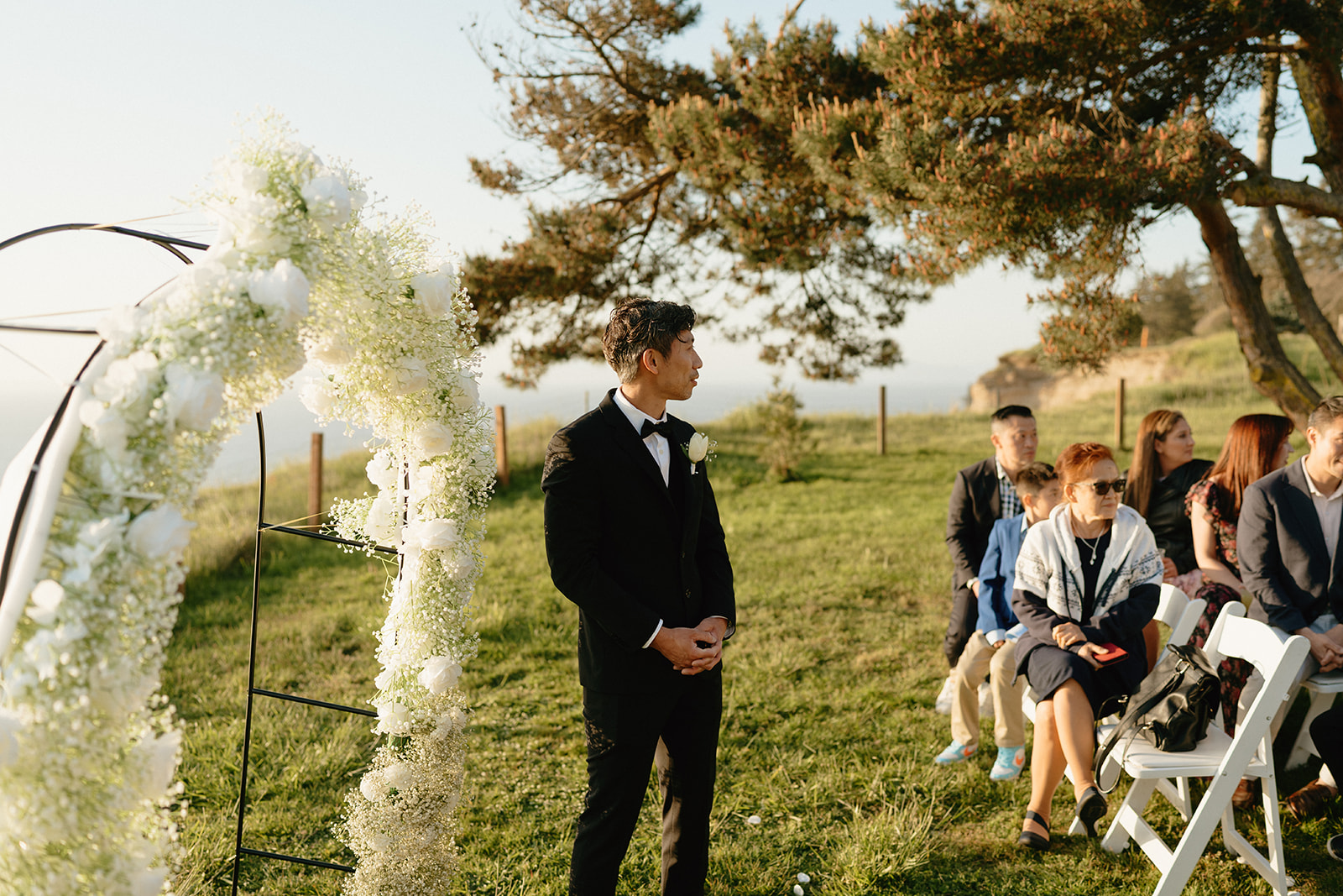 Groom standing under the floral arch, waiting for the ceremony to begin at a Whidbey Island wedding.