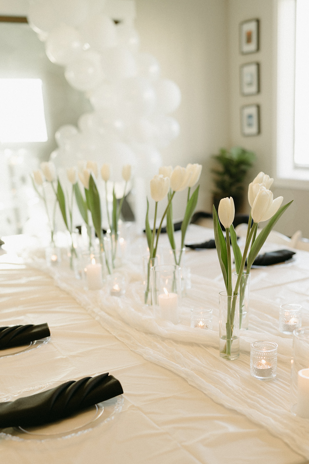 Minimalist wedding tablescape with white tulips, candles, and black napkins at a Whidbey Island reception