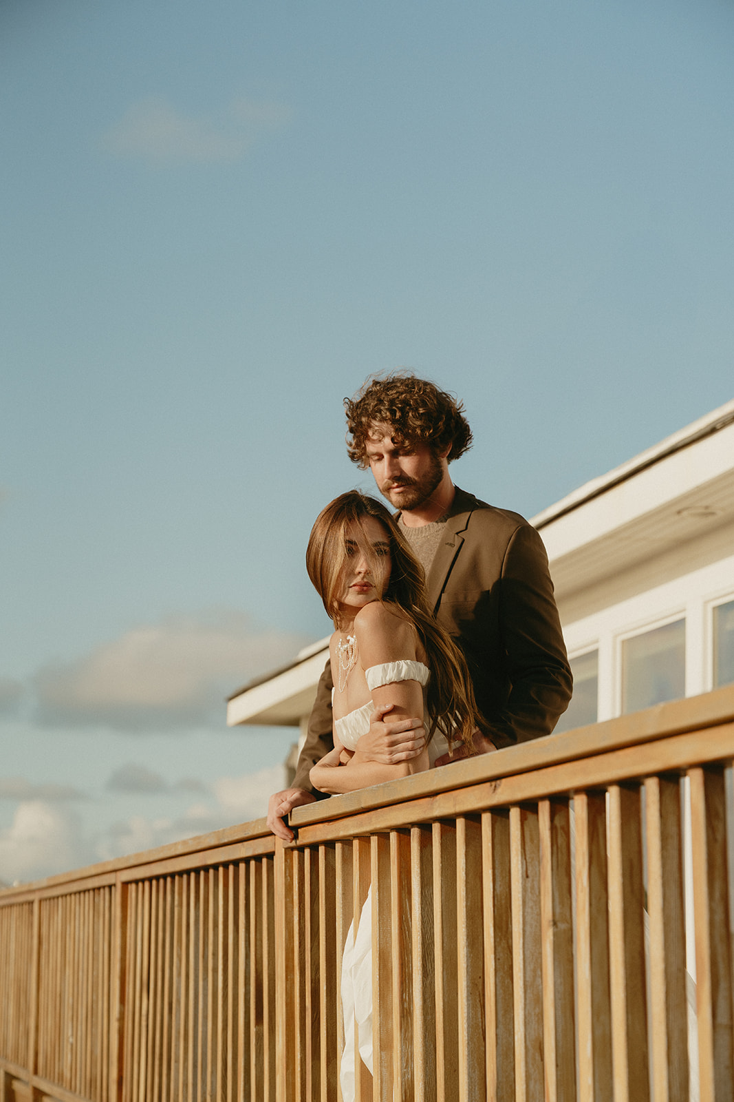 A close, cinematic portrait of a couple during their Oregon Coast elopement, the bride’s pearl necklace catching the last light of day.