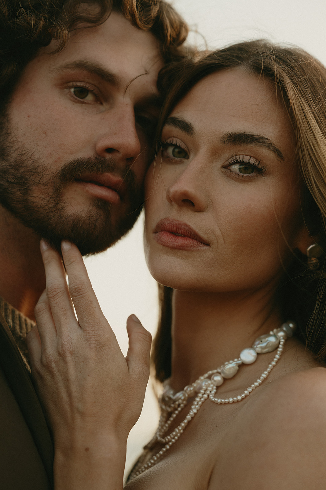 Two faces pressed close together, their expressions soft and still—capturing both strength and tenderness in one shared breath.