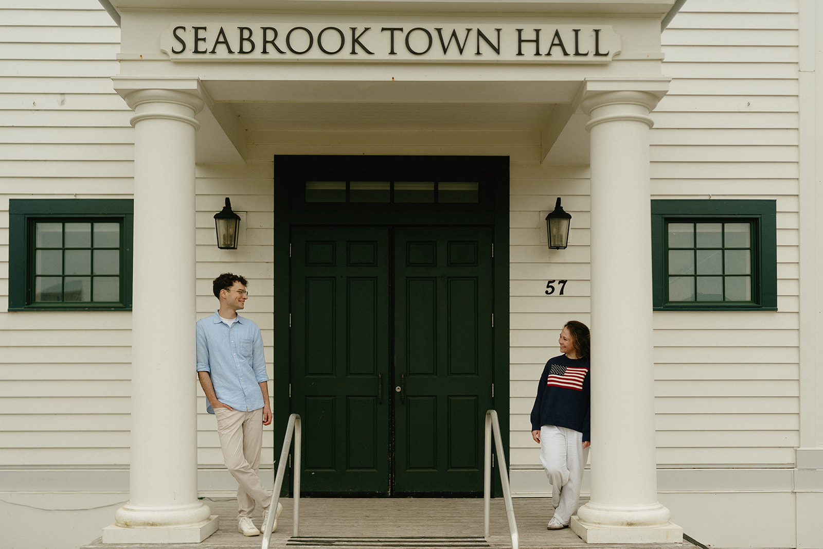 Couple facing each other on the steps of Seabrook Town Hall, a classic backdrop for couples seeking simple, timeless ideas for engagement photos.