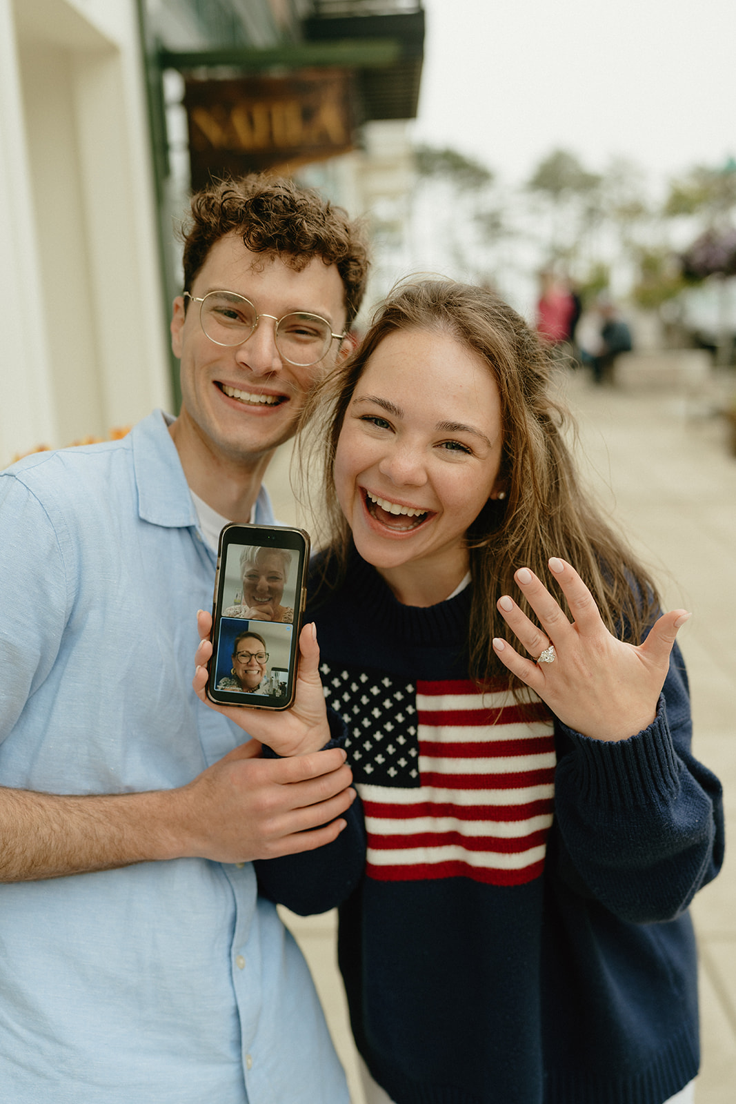Couple beaming with joy while video chatting loved ones, showing off the engagement ring and sharing the moment.