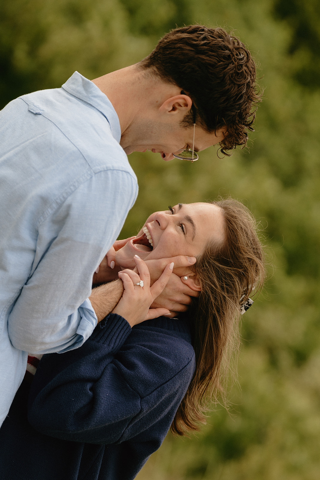 Joyful close-up of a woman laughing in her partner’s arms, her engagement ring catching the light—capturing candid ideas for engagement photos full of emotion.