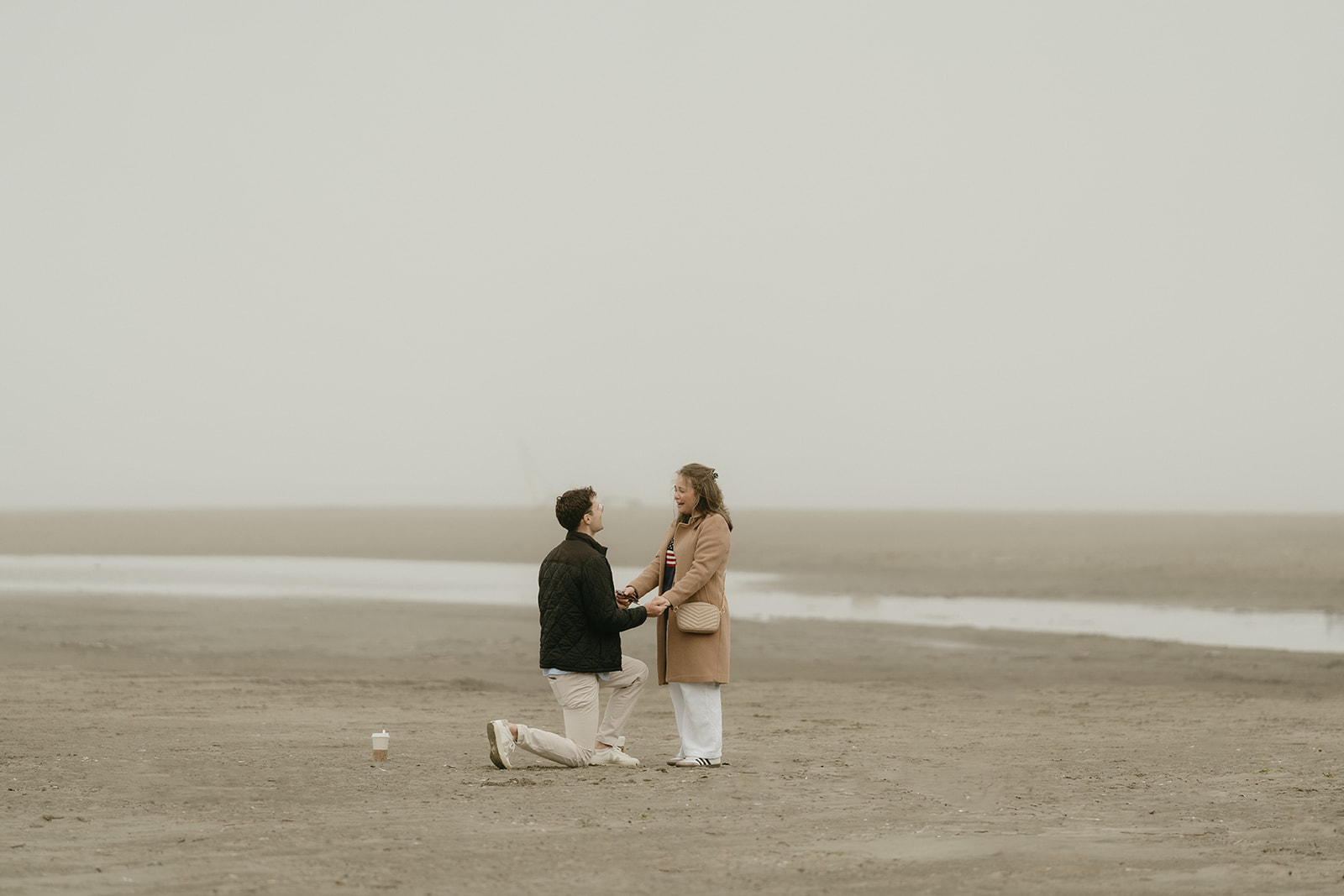 Candid beach proposal with the couple holding hands, capturing raw emotion and offering timeless ideas for engagement photos.