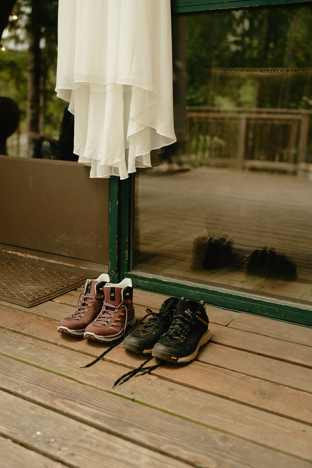 Bride and groom's hiking boots sitting on porch outside of A-frame cabin