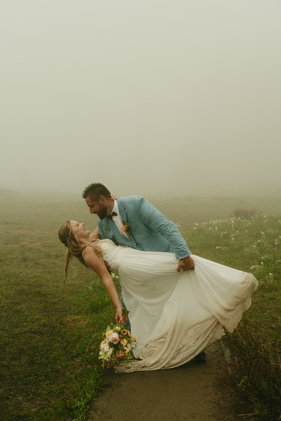 Groom dips bride after elopement and leans in to kiss her