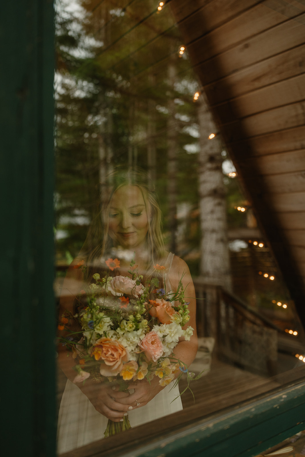 Bride holding bouquet while looking outside window