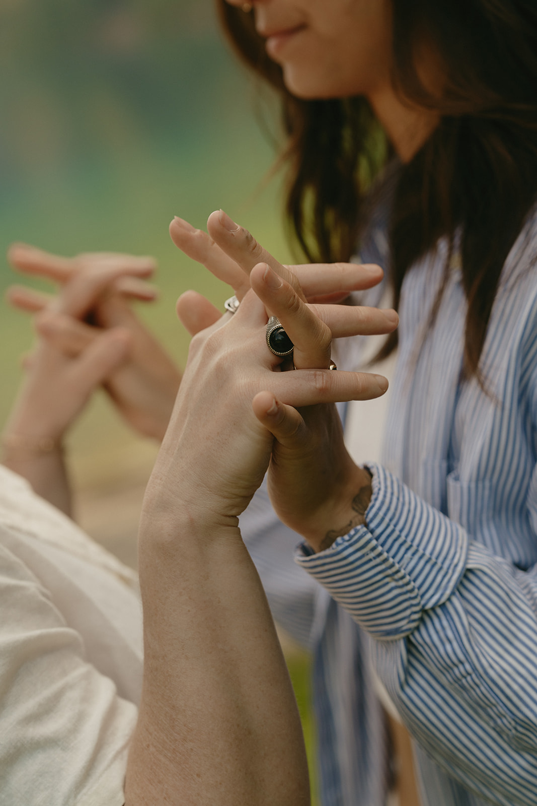 A close-up of intertwined hands, wedding rings visible, capturing tenderness in a simple, honest gesture.