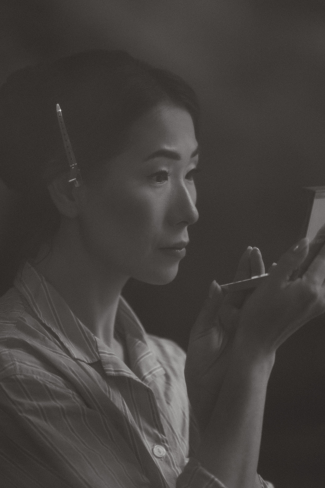 Intimate black and white portrait of a bride quietly applying makeup.