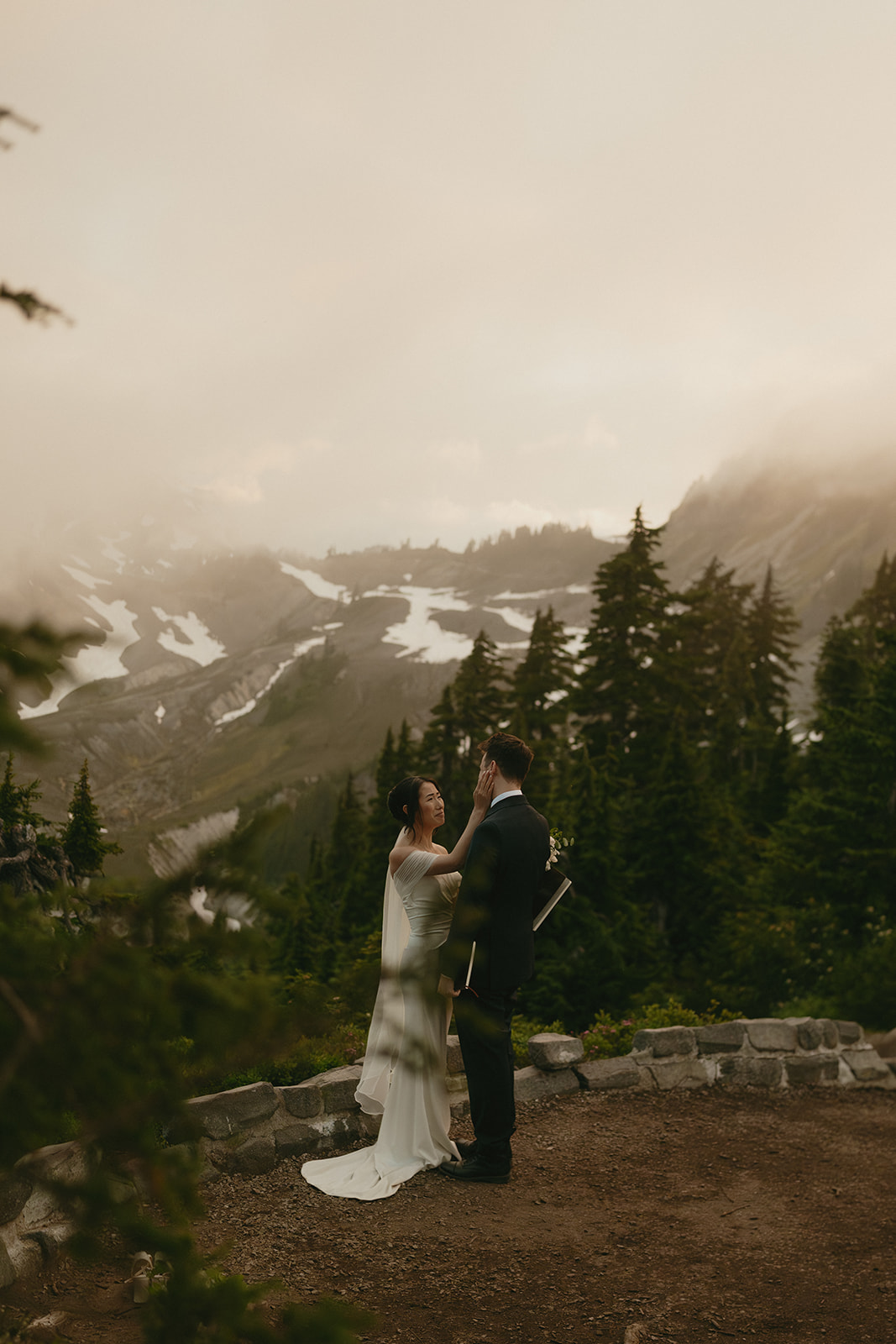 Bride gently touches the groom’s face during a tender ceremony while eloping in Washington.