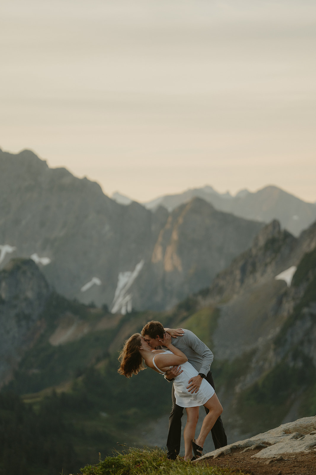 Man dip kisses woman in a romantic and joyful celebration of recent engagement in washington