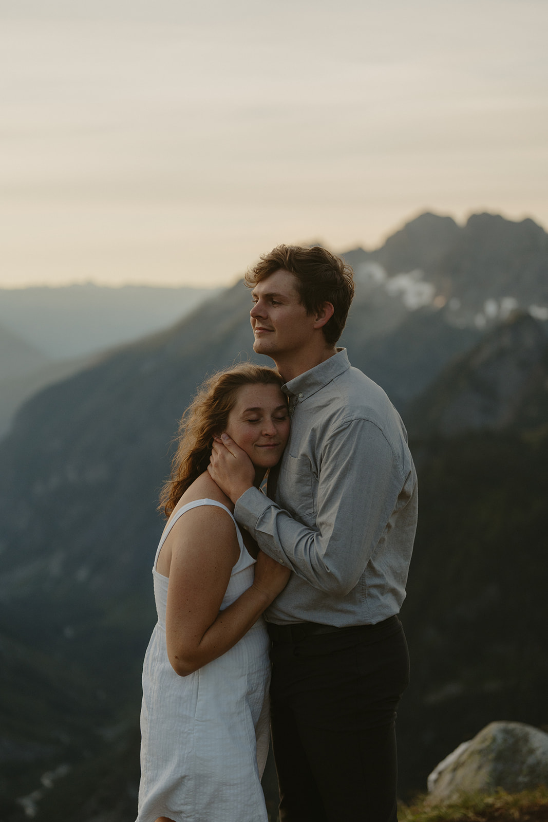 woman rests her head against man's chest while he brings her in close for a romantic hug