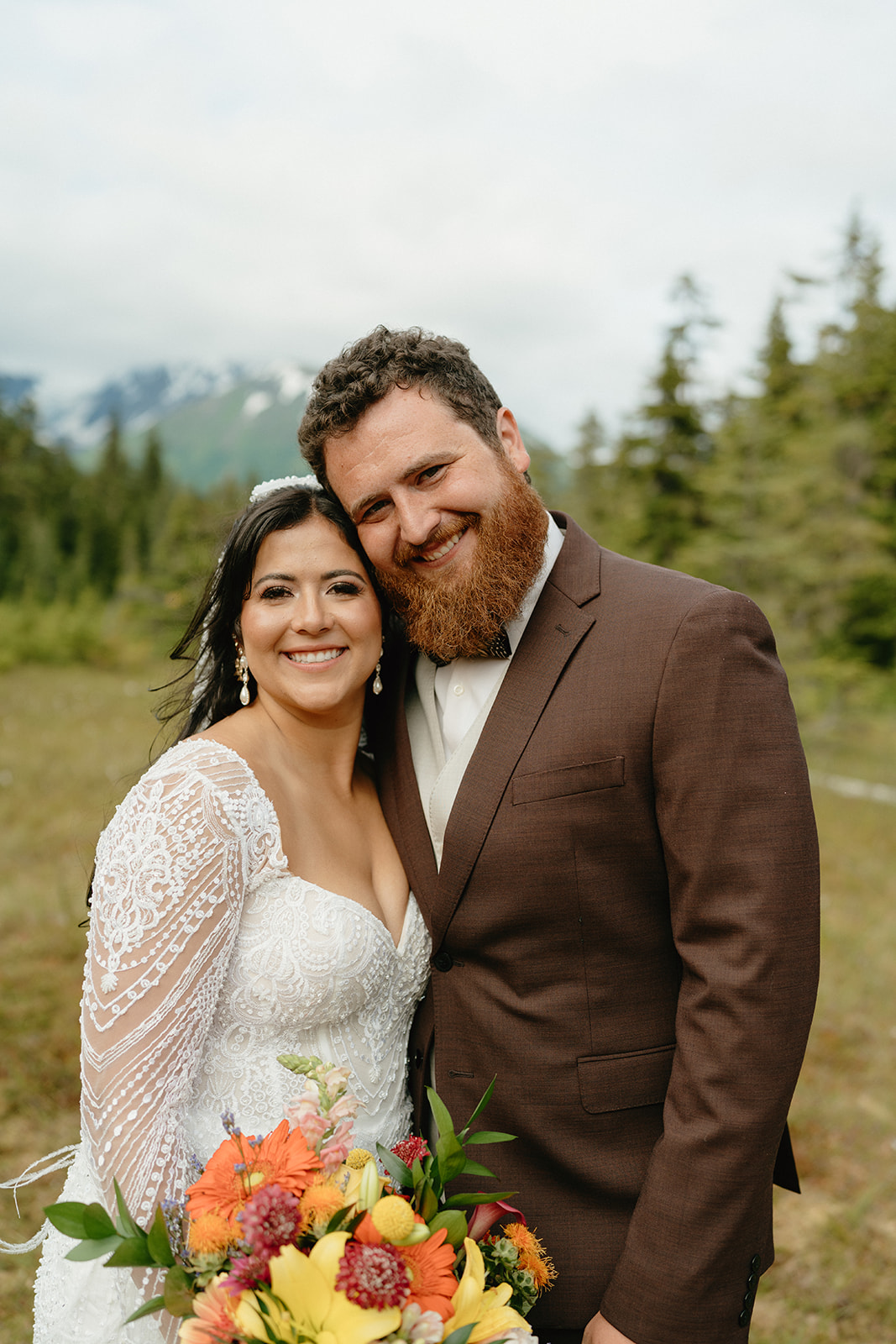 Bride and groom touch cheeks together and smile during outdoor bridal portraits.