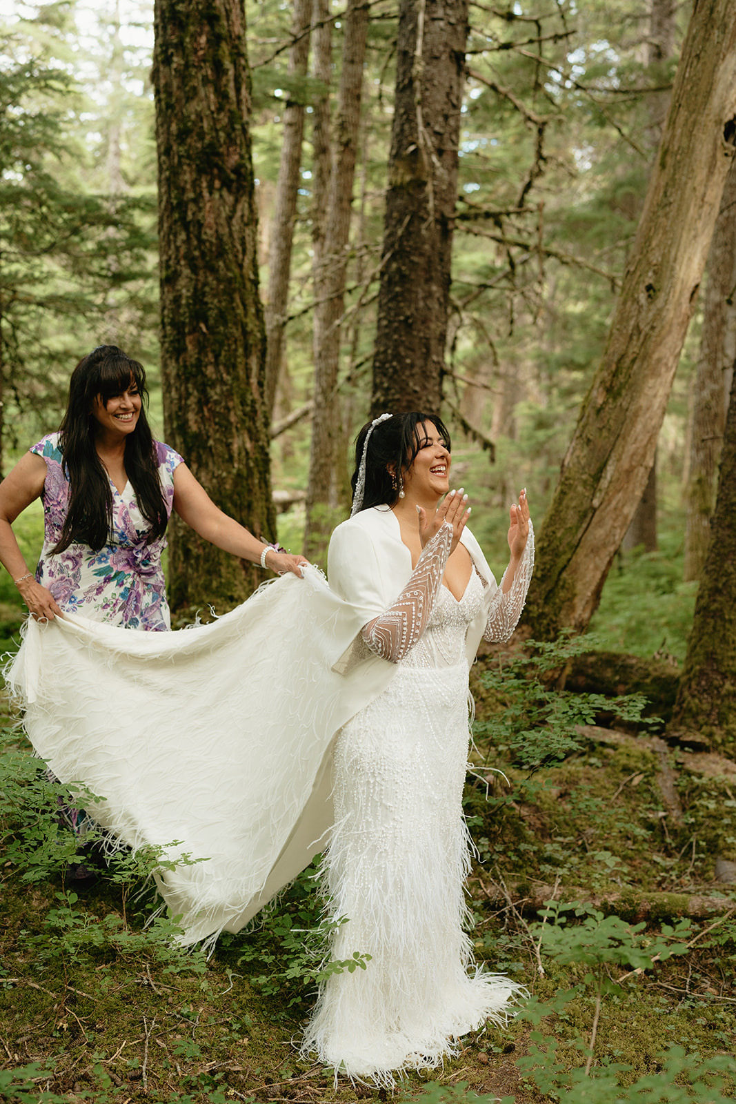 Bride throws hands in air in nervous excitement before seeing her girls in her wedding gown.