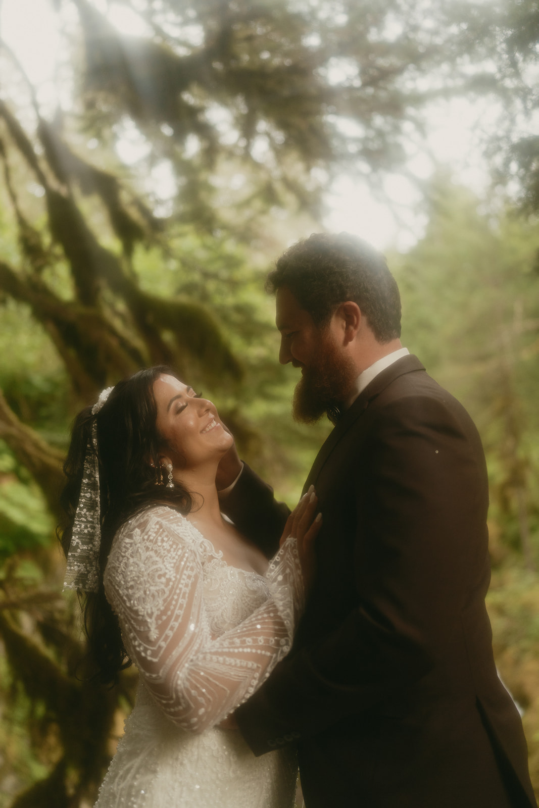 Close up of bride and groom embracing and smiling at one another.