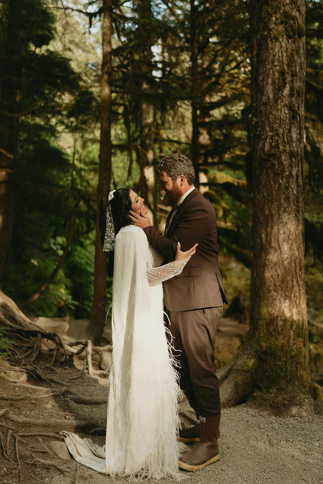 Groom holds bride's face and looks at her lovingly after eloping to Alaska.