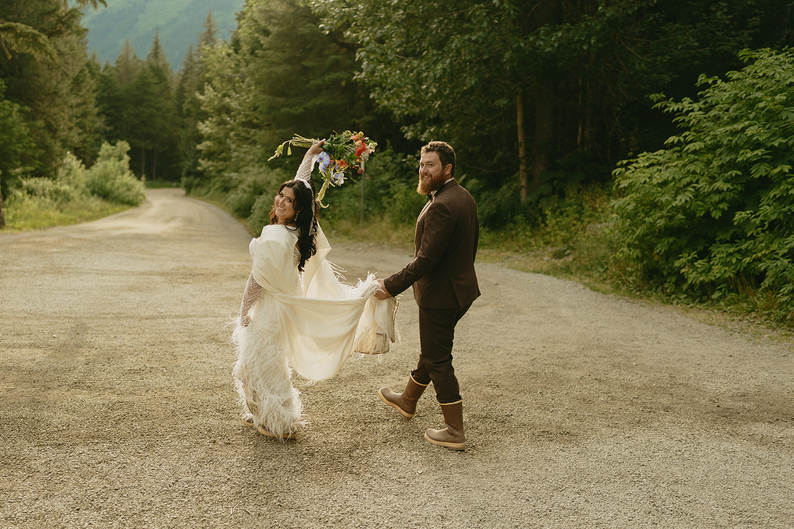 Bride holds up bouquet over her shoulder as her and her groom begin to walk away together.
