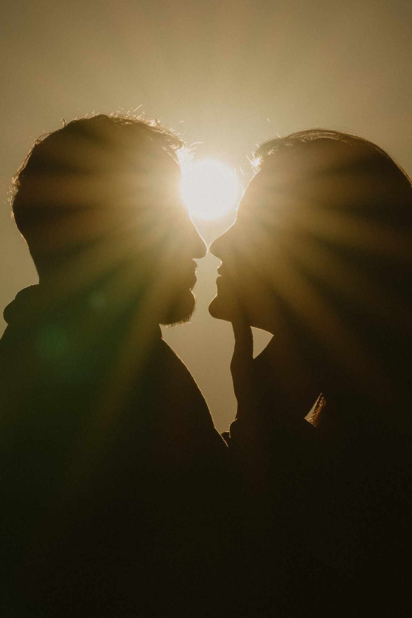 A couple kissing during golden hour on the Washington coast, the silhouettes of their side profiles emphasized