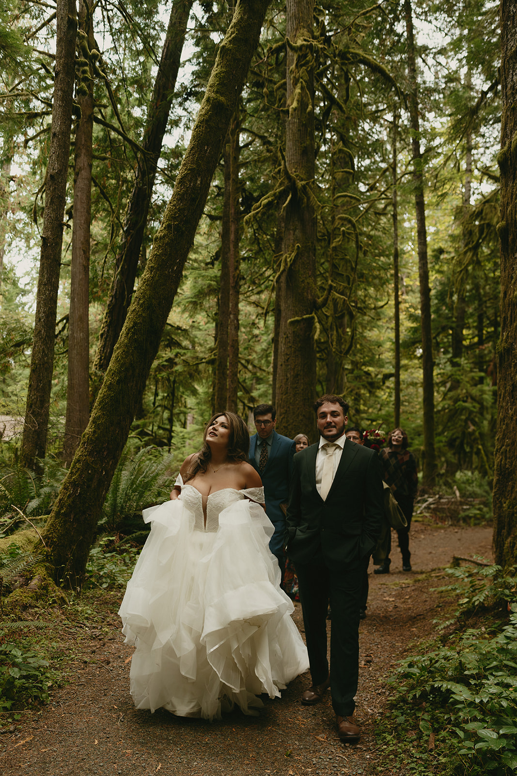 A wooden trail sign nestled in the ferns points toward Lake Crescent Lodge, Moments in Time Trail, and Marymere Falls.