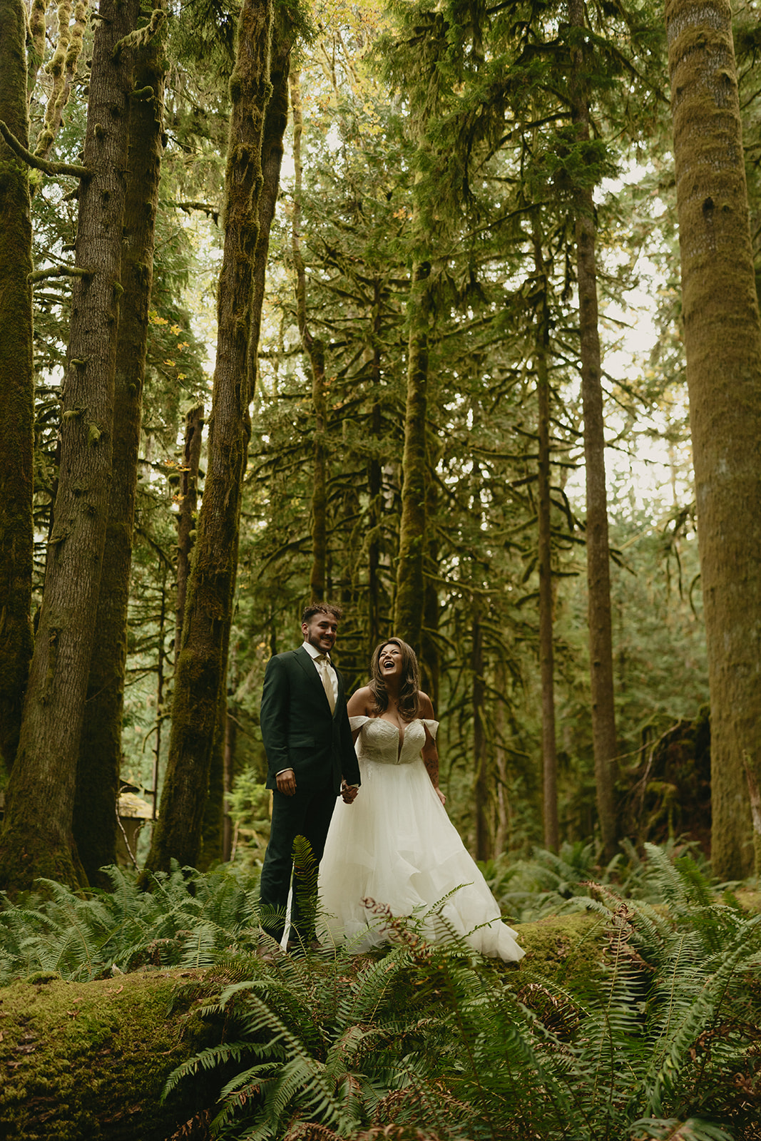 The couple walks slowly down a moss-covered path in the heart of the rainforest, wrapped in the stillness of Olympic National Park.