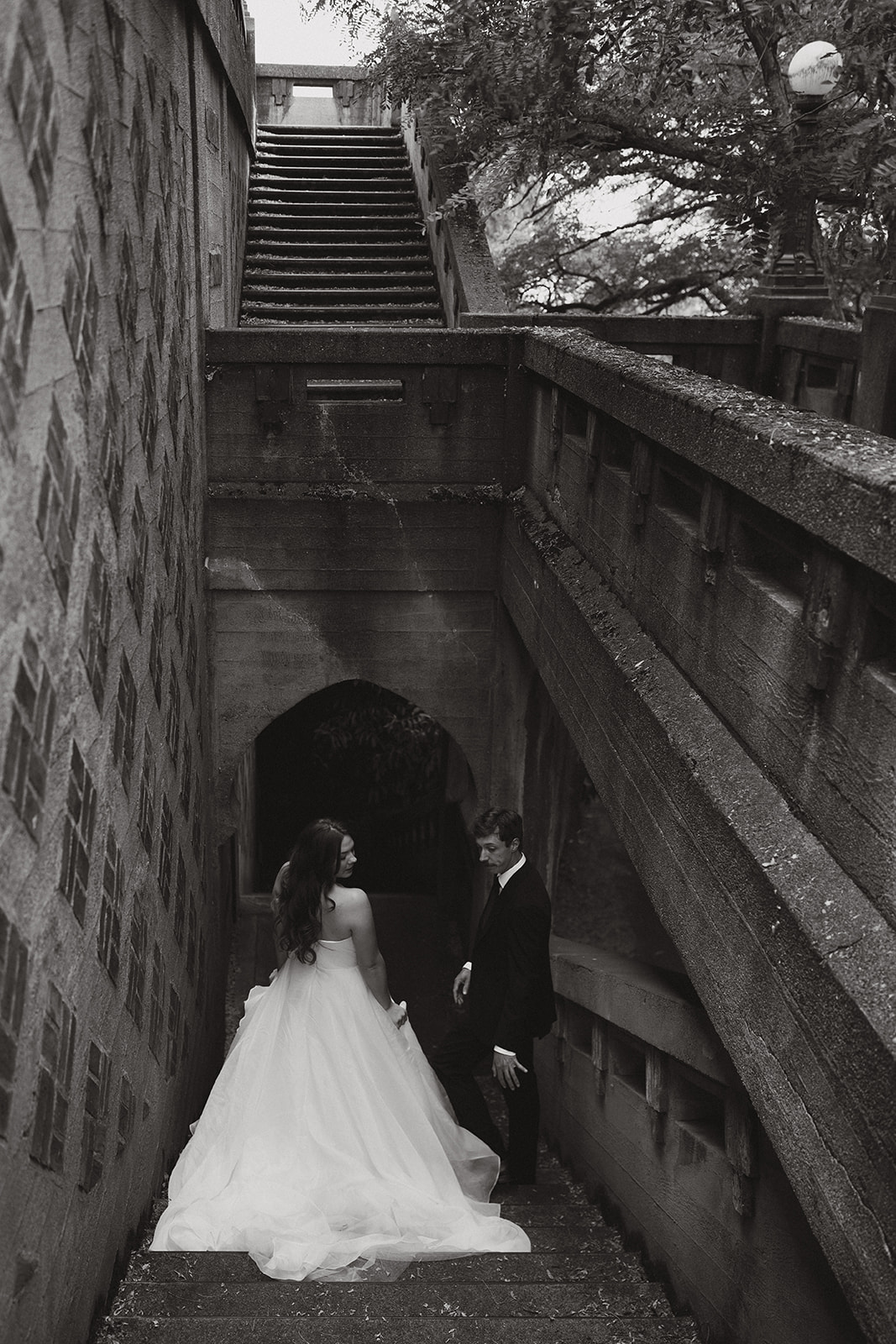 Black and white image of the couple walking down a dramatic stone staircase during their wedding in Washington.
