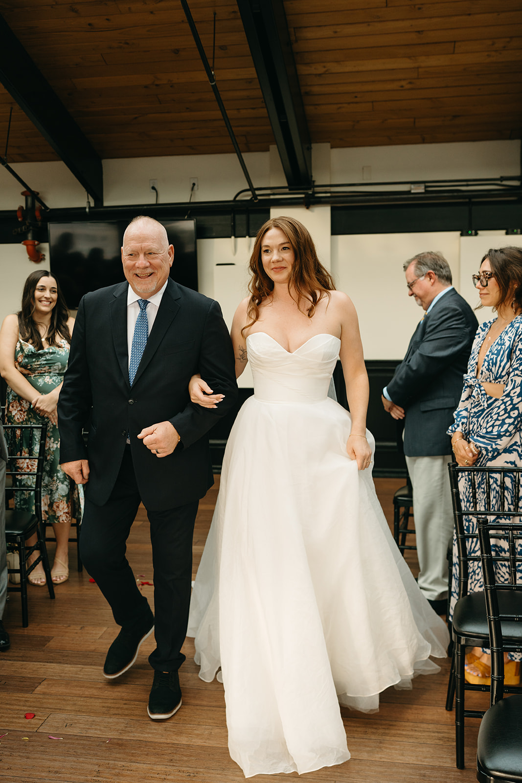 Bride walks down the aisle with her father, smiling as she approaches the groom on her wedding day in Washington.