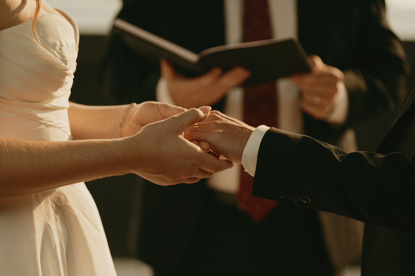 Close-up of the bride placing the wedding ring on the groom’s hand during their wedding ceremony in Washington.