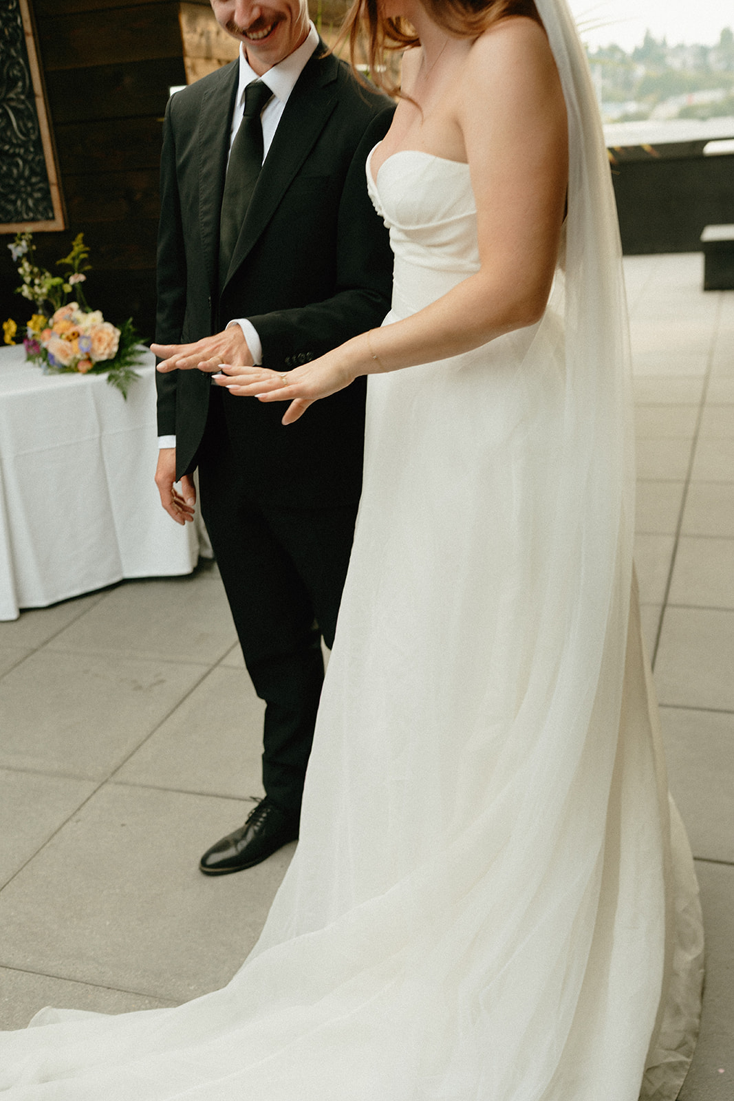 Bride shows her wedding ring to the groom in a joyful moment just after the ceremony.