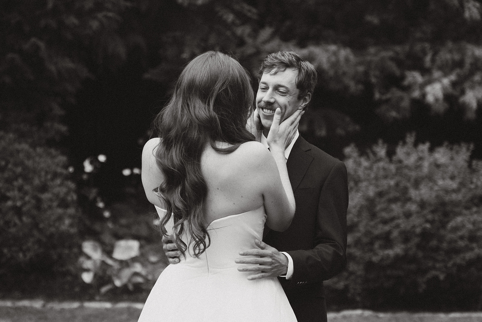 Timeless black and white portrait of the bride gently holding her groom’s face, a quiet, tender moment during their wedding in Washington.