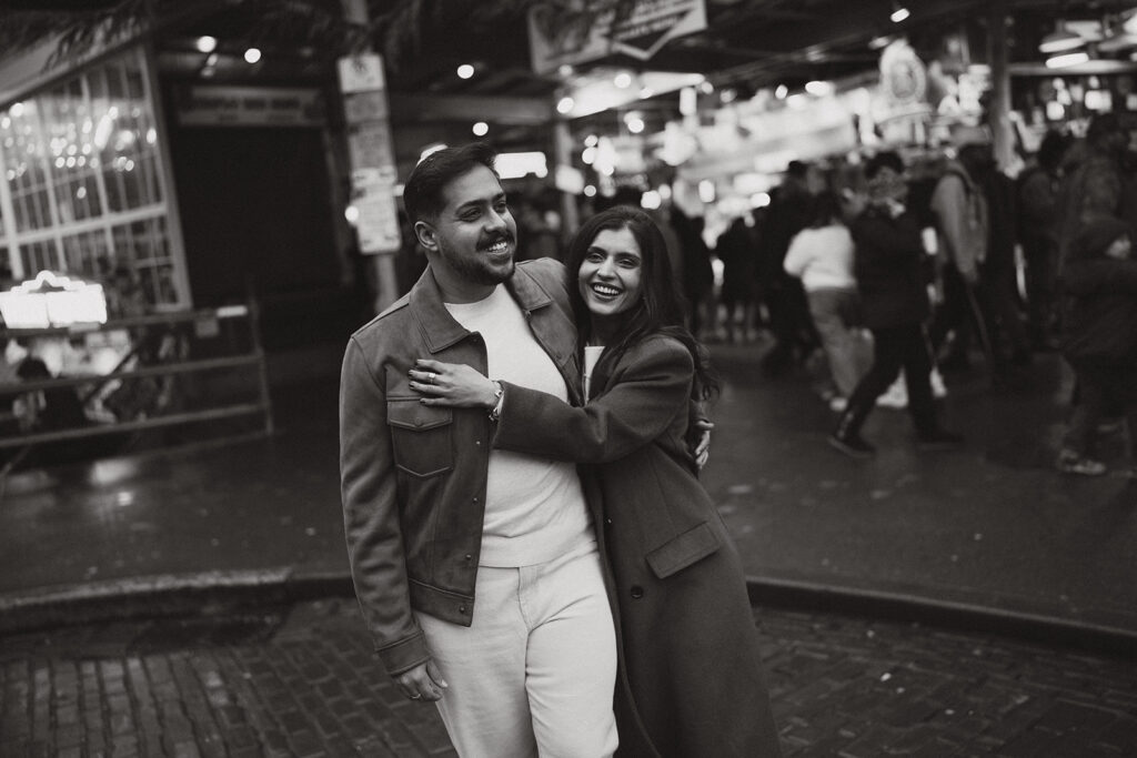 Black and white cinematic image of a couple hugging while they walk