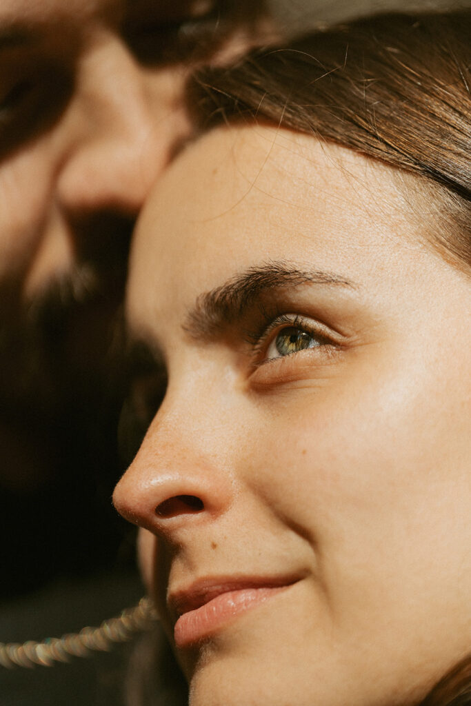 Couple embracing each other as the light illuminates the girl's bright green eyes
