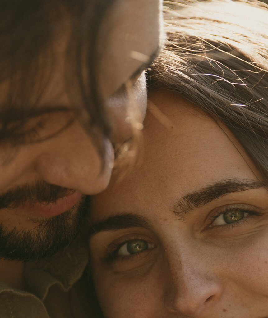 Close up image of a couple's faces, with the girl's green eyes in focus