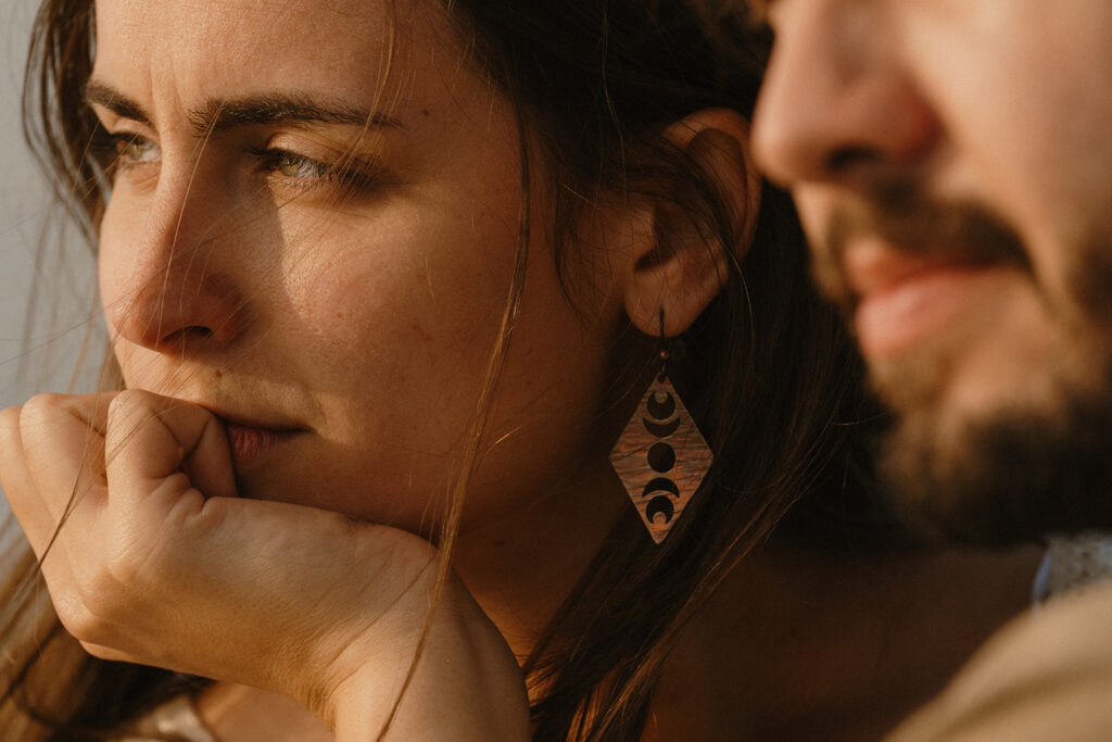 Close up image of a couple looking out towards the water as they embrace on a Washington State ferry